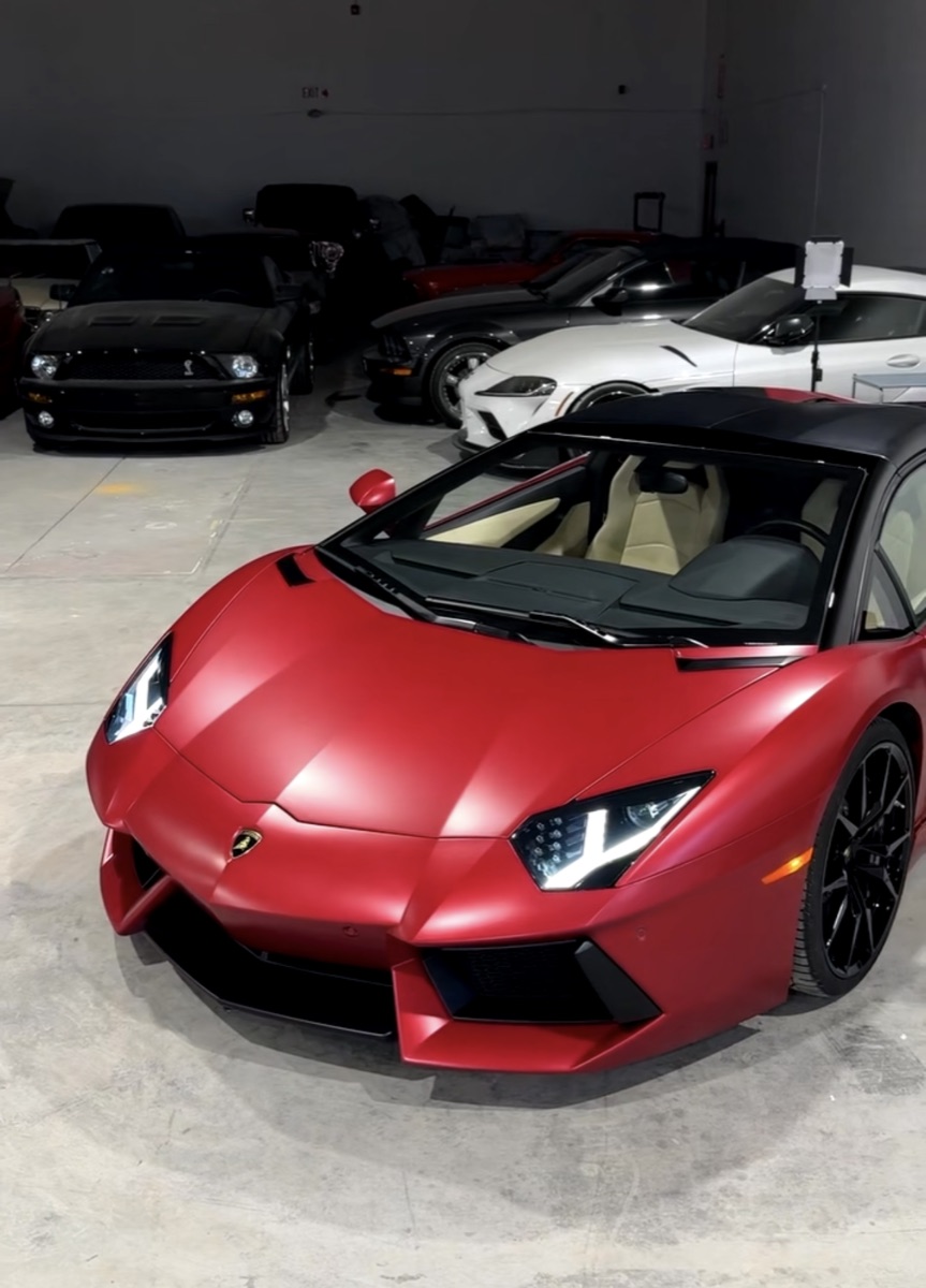 Matte red Lamborghini Aventador with an edge-wrapped film finish inside the boutique