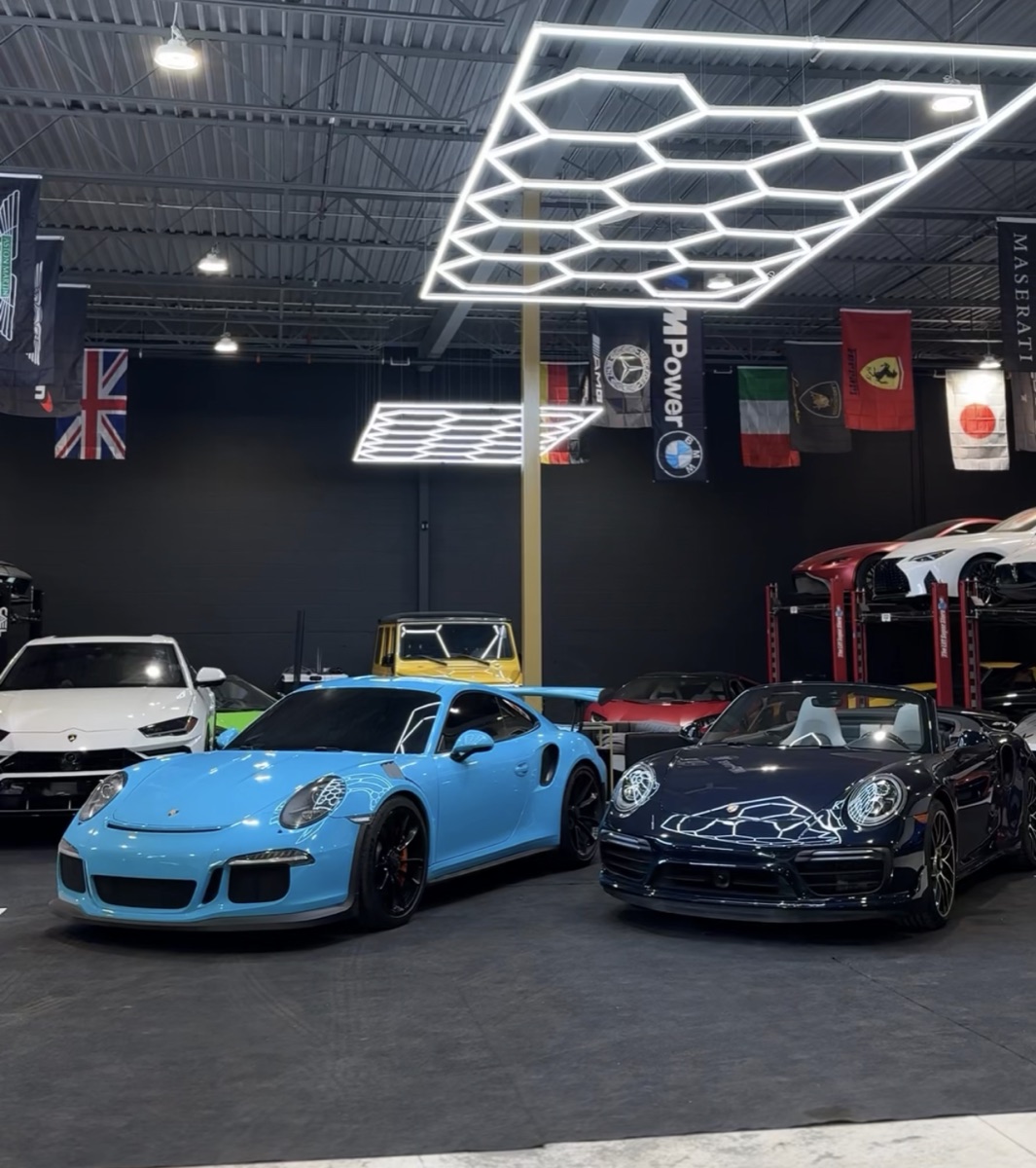 Exotic cars parked under the hex lighting inside Luxotic Auto Boutique