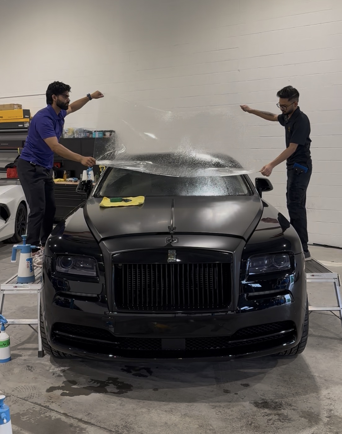 Windshield protection film being installed on a black Rolls-Royce Wraith